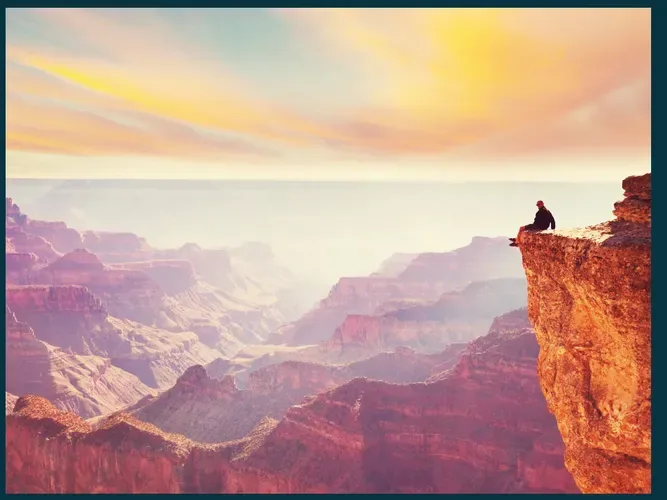 A hiker overlooking the Grand Canyon at sunset