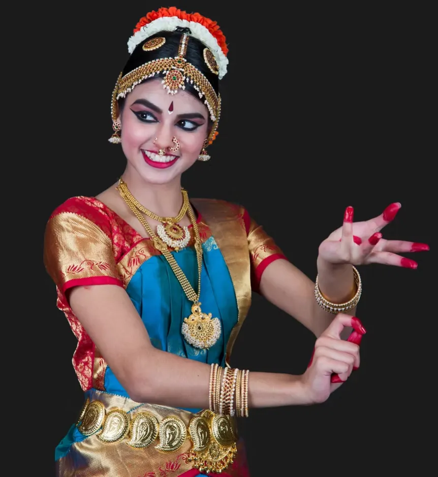 Sainrithya dancer performing against a dark backdrop