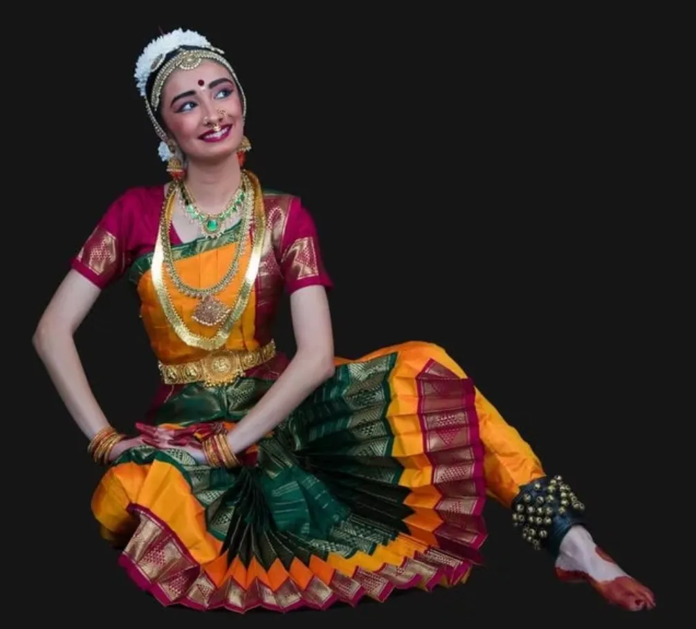Sainrithya dancer performing in a teal and gold costume
